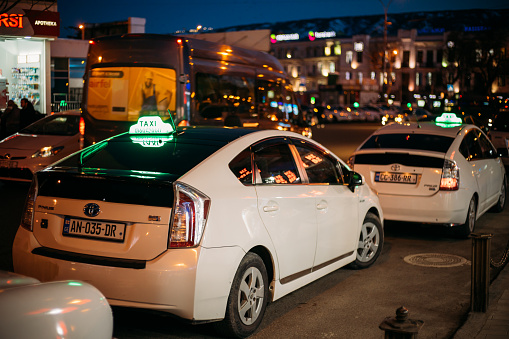 Tbilisi, Georgia - March 28, 2022: View On White Toyota's Prius Used As A Taxi. Conception Of City Trips. White Toyota Prius Plus Taxi Cars Waiting For A Customers In Tbilisi, Georgia. Empty Taxis Parked At Streets Of Tbilisi.