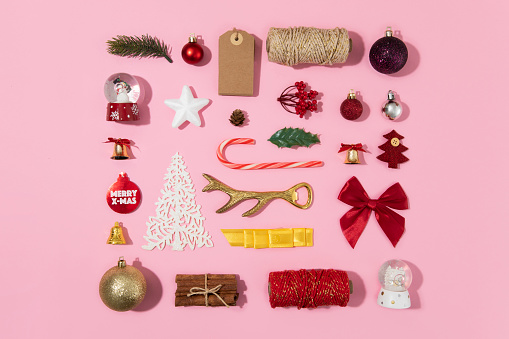 Christmas ornaments, gifts and candy canes on pink background