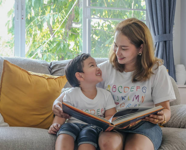 asian mother and son spending time together - child reading mother book imagens e fotografias de stock