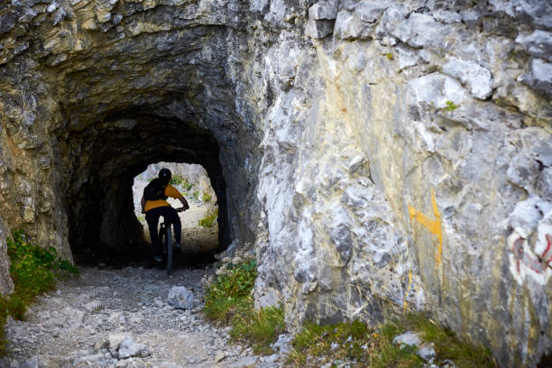 istock Mountain biker rides through narrow tunnel 1440209428