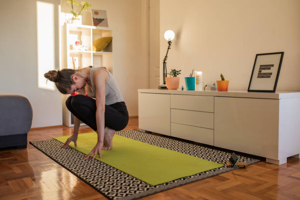 istock Young woman is doing yoga at home 1440211278