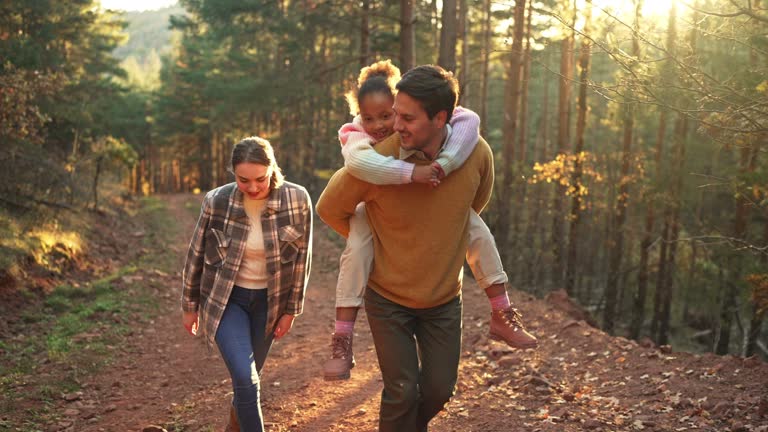 Family Walking Along Track In Autumn Countryside