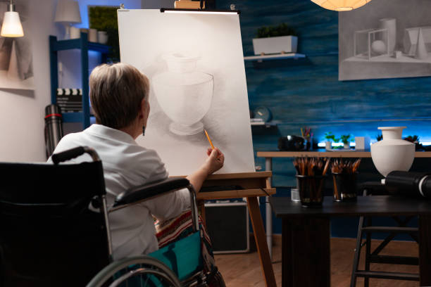 istock Disabled elder artist drawing vase design on canvas 1440212823