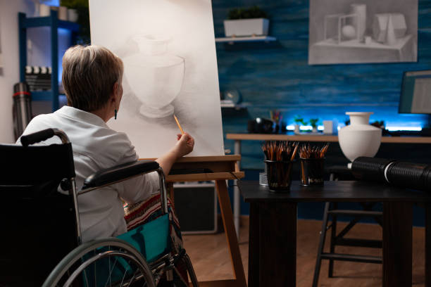 istock Disabled elder artist drawing vase design on canvas 1440212849