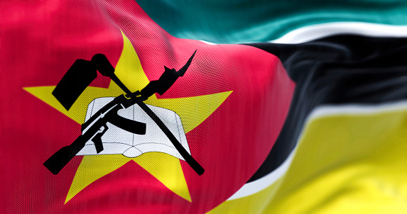 Close-up view of the Mozambique national flag waving in the wind. The Republic of Mozambique is a sovereign state of East Africa. Fabric textured background. Selective focus. 3D illustration