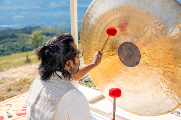 istock Man playing bronze gong with drumsticks, sound therapy 1440215602