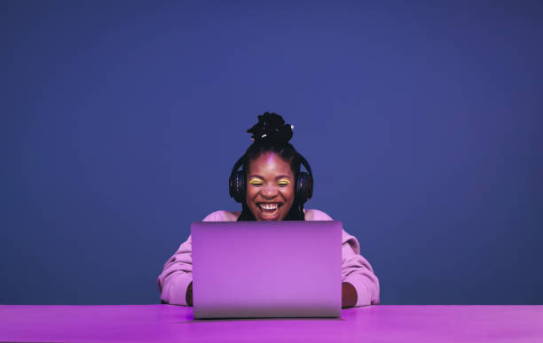 cheerful female gamer winning an online game on a laptop - generatie z stockfoto's en -beelden