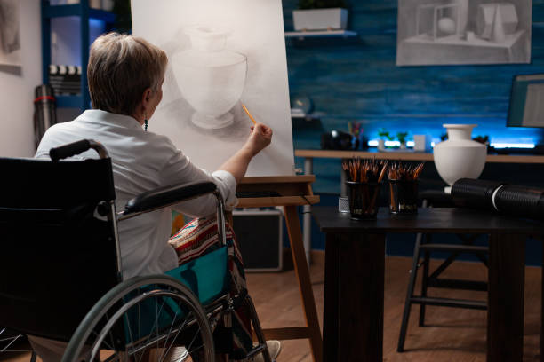 istock Focused retired art teacher living with disability doing creative artwork in pencil drawing vase model 1440217450
