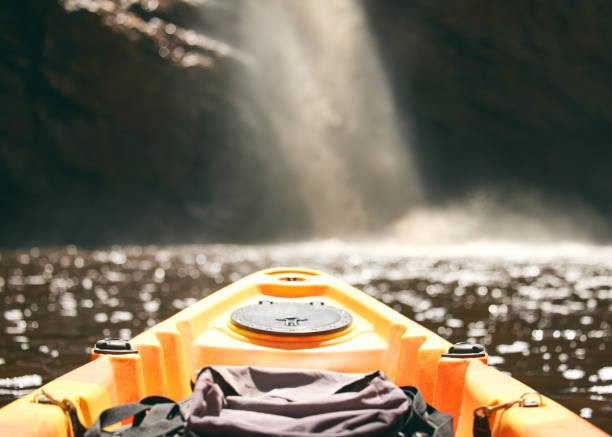 una piccola barca da pesca sul mare agitato durante una tempesta al buio di notte con il sole che passa in lontananza. pescatori sul mare. cielo scuro e tempestoso. - extreme sports kayaking kayak adventure foto e immagini stock