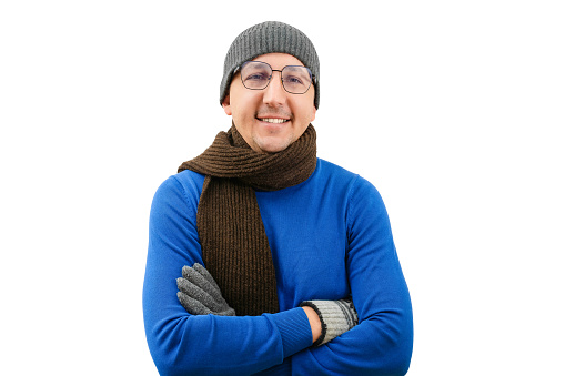 Young happy man in warm clothes looking at the camera on a white background. Winter cold season concept.