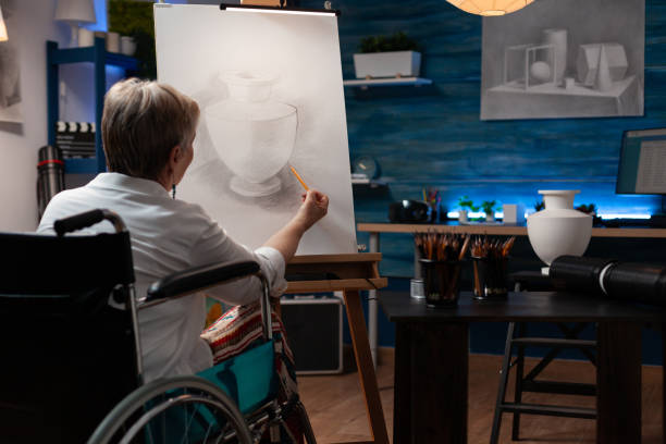 istock Focused retired art teacher using wheelchair doing creative artwork in pencil drawing vase model 1440217983
