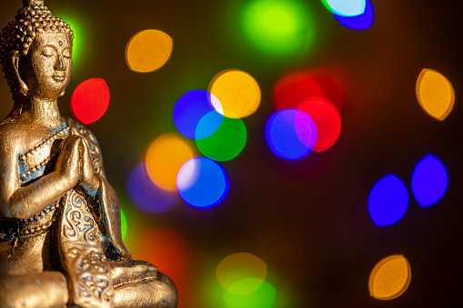 a golden buddha statue against a colored background
