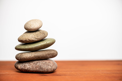 stacked stones against a white background with copy space
