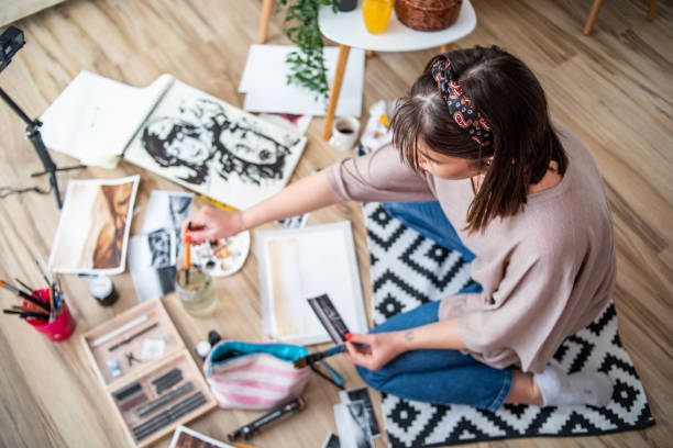 Creative female young artist painting at home stock photo