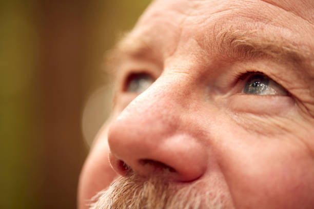 Zbliżenie starszego mężczyzny wychodzącego na zewnątrz z zbliżeniem na twarz i oczy – zdjęcie