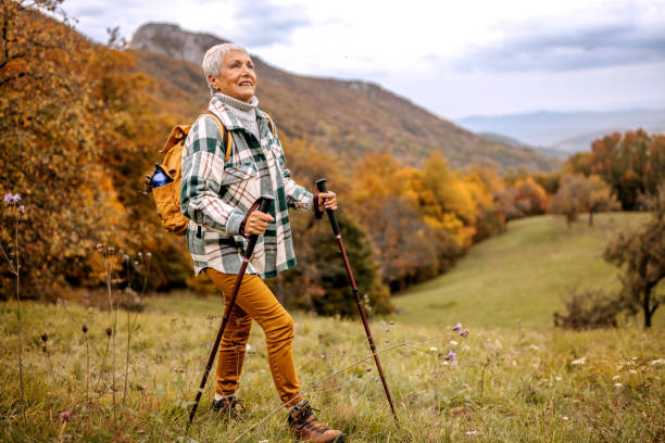 Enjoying nature Senior woman hiking nordic walking pole stock pictures, royalty-free photos & images