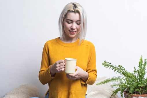 Smiling Woman Holding Coffee Cup Against White Background