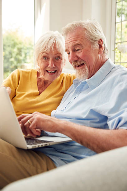 istock Retired Senior Couple Sitting On Sofa At Home Using Laptop 1440224349