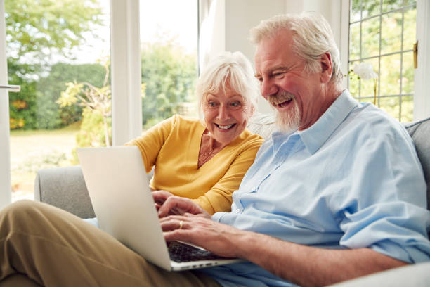 istock Retired Senior Couple Sitting On Sofa At Home Using Laptop 1440224388