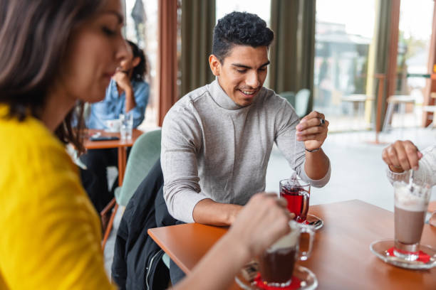 istock Group Of Friends Enjoying Warm Winter Drinks Inside A Cafe 1440225278