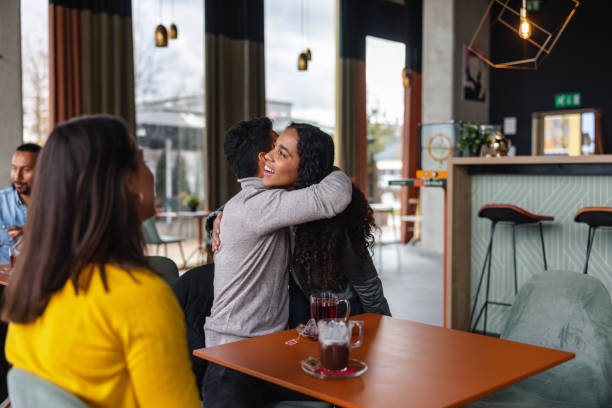 istock Friends Greeting and Embracing Each other In A Cafe 1440225364