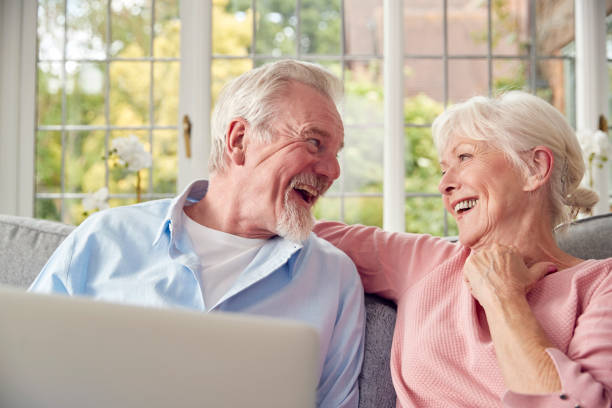 istock Retired Senior Couple Sitting On Sofa At Home Using Laptop 1440225400
