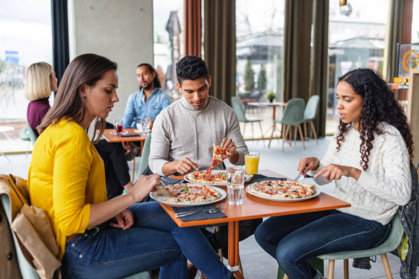 istock Group Of Friends Having Fun While Eating Pizzas At A Restaurant 1440225416