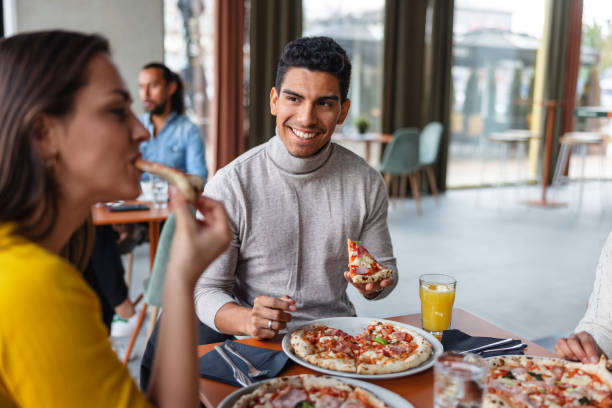 istock Group Of Friends Having Fun While Eating Pizzas At A Restaurant 1440225419