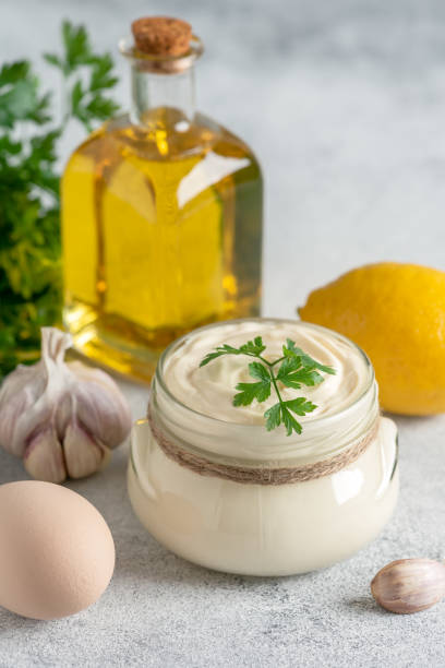 istock Aioli sauce with ingredients on a light gray grunge background. Side view, selective focus, copy space. Homemade mayonnaise. Vertical image. 1440227223