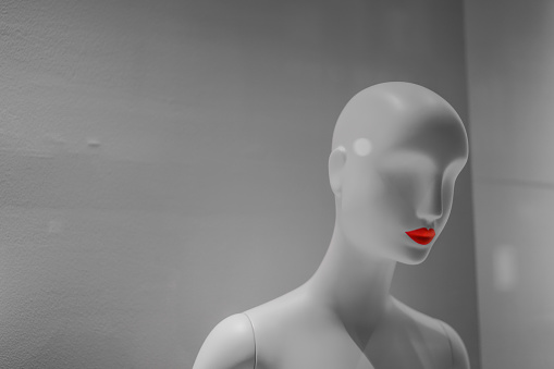 A recognizable dummy's head in front. There are grub of mannequins body behind her. They are isolated with black background.