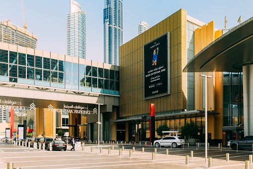 Dubai, UAE, United Arab Emirates - May 28, 2021: Cars parking near Dubai shopping mall. Cars parking near cinema, Dubai shopping mall. View of car parking near shopping center Dubai mall in summer day. Urban background.