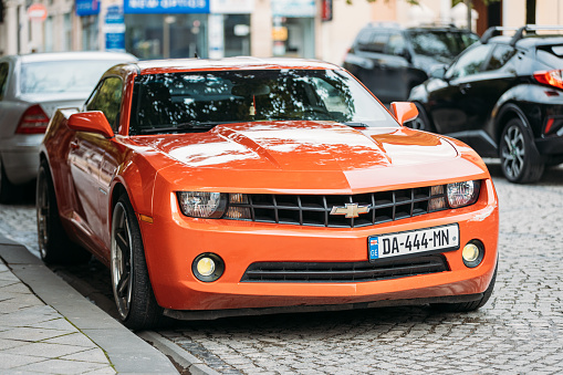 Batumi, Adjara, Georgia - March 20, 2022: Orange Chevrolet Camaro car parked on street. Sixth generation