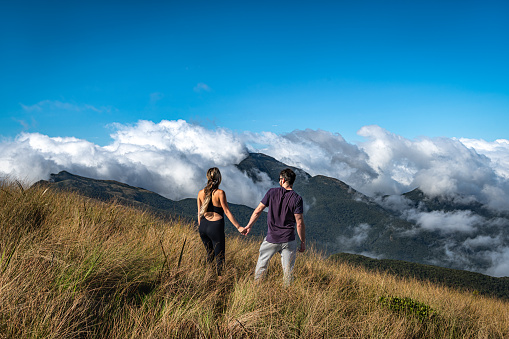 Young couple of hikers holding hands and enjoying the scenery