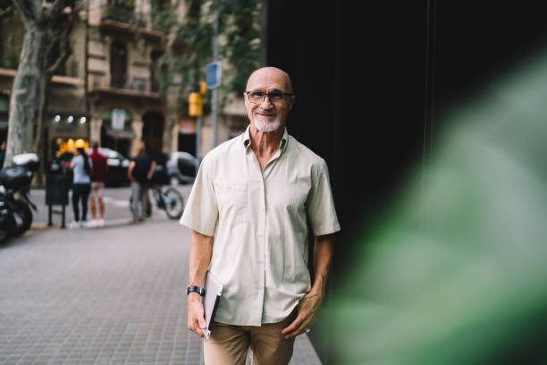 istock Happy aged man with tablet standing on street 1440237930