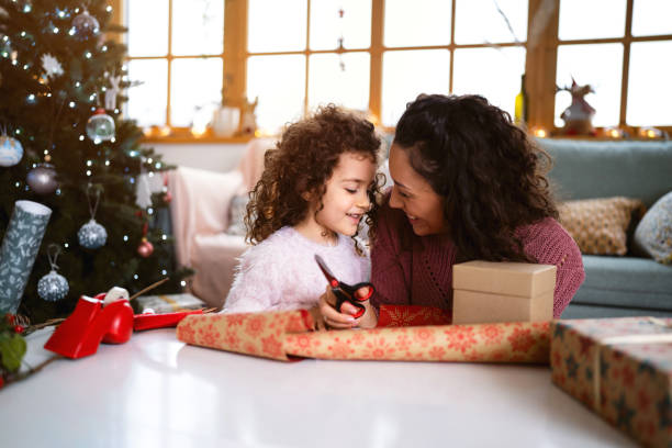 istock Mother and daughter having fun while wrapping Christmas presents 1440238534