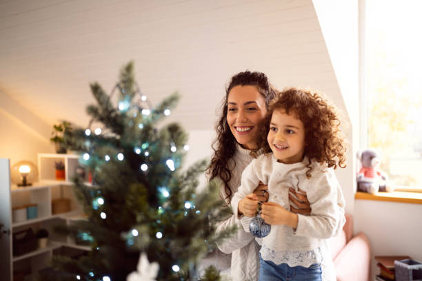 istock Excited mother and daughter decorating Christmas tree 1440240537