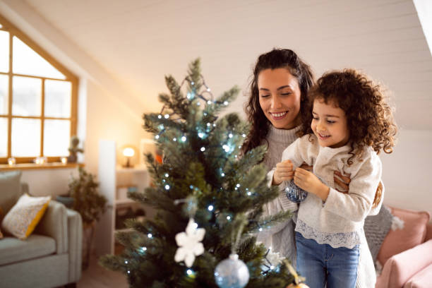 istock Excited mother and daughter decorating Christmas tree 1440241212