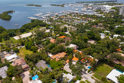 Aerial drone view on Miami residential neighborhood, port with yachts, islands, ocean, sailing boats, tropical vegetation, swimming pools