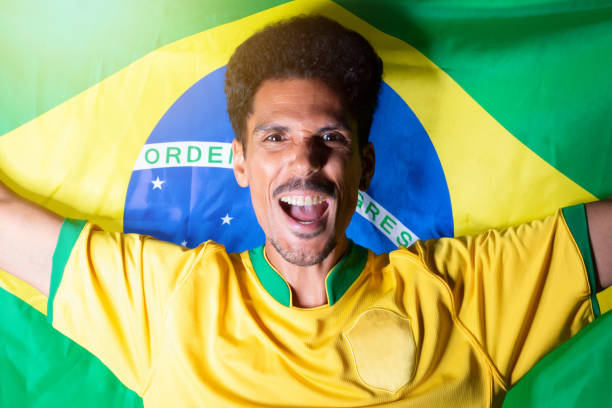 istock Black Man Holding Brazil Flag Behind Celebrating 1440247318