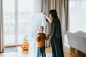 ハロウィーンの幽霊の衣装を作る日本の母と息子