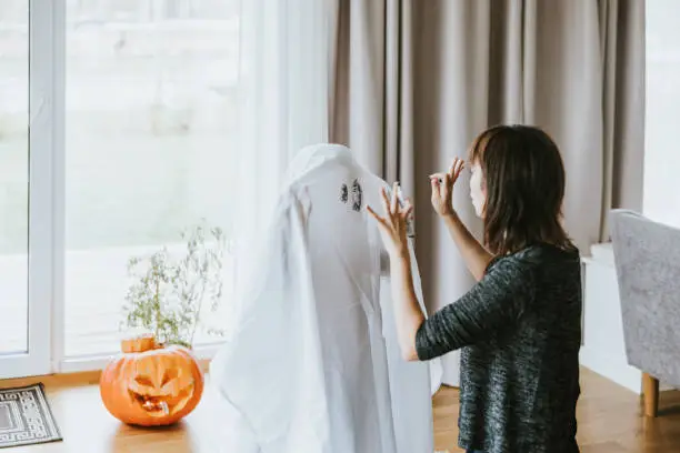 Japanese mother and son making ghost costume for halloween trick or treating.