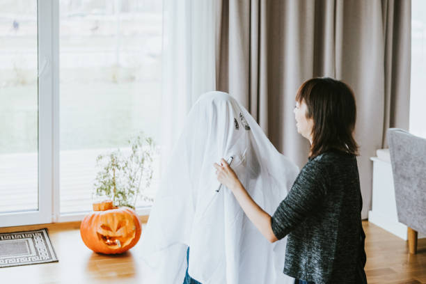 Japanese mother and son making ghost costume for halloween trick or treating.