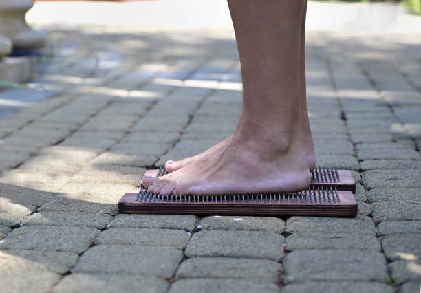 istock Alternative medicine and Mindfulness practice, needle standing- standing on a sadhu board, barefoot. 1440252378