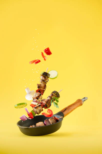 Shish kebabs with vegetables on a yellow background