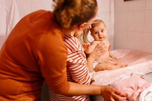 Same sex lesbian mothers giving a bath to their daughter