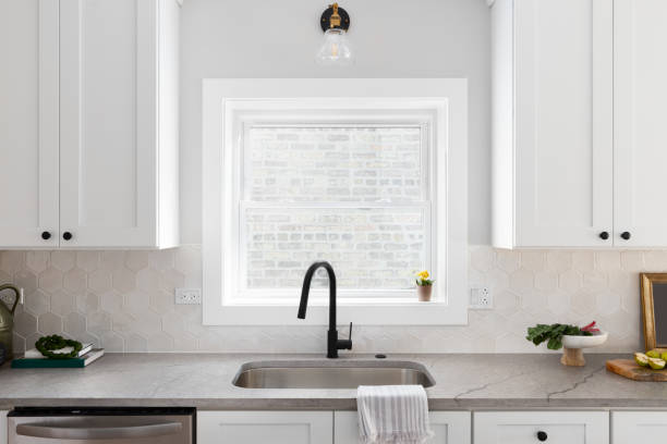 istock A kitchen sink detail with hexagon backsplash and white cabinets. 1440258880