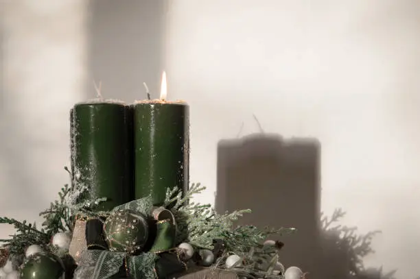 Decorated Advent wreath with four green candles with first one burning