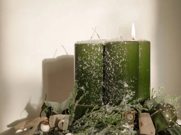 Decorated Advent wreath with four green candles with first one burning