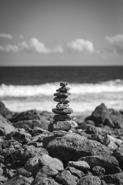 pile de roches empilées les unes sur les autres en parfait équilibre à la côte rocheuse de la mer - balance simplicity nature beach photos et images de collection