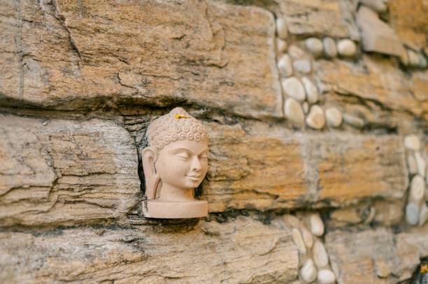 Delhi, India – November 02, 2022: The pink Stone Buddha Statue on the wall